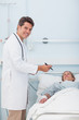 © WavebreakmediaMicro - Doctor standing next to his patient while holding a chart