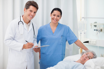 Wall Mural - Doctor smiling while holding a clipboard