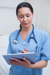 Wall Mural - Nurse touching a tablet computer