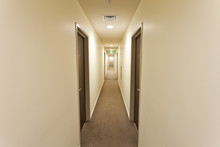 Long Corridor With Hotel Room Doors And Exit Sign