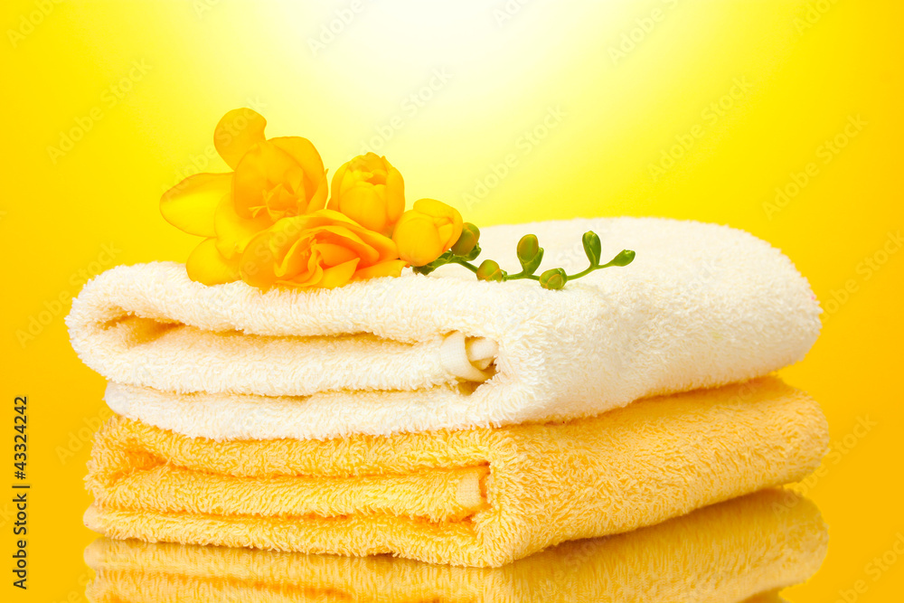 colorful towels and flowers on yellow background