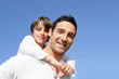 © auremar - Boy riding piggy back on his father's back