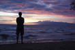 © Roberto Westbrook/Blend Images - Caucasian man standing on beach viewing sunset