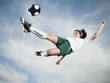 © Erik Isakson/Blend Images - Caucasian teenager kicking soccer ball in mid-air