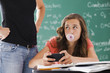 © Mike Kemp/Blend Images - Frustrated teacher watching student with cell phone and gum