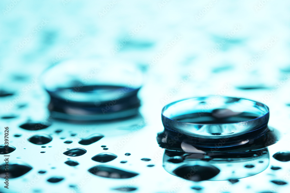 contact lens with drops on blue background