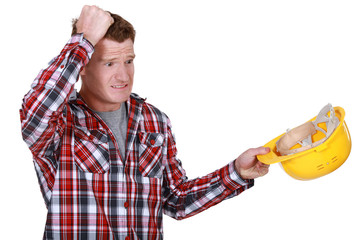 Confused builder removing hard hat