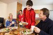 © Monkey Business - Helpful Teenage Children Serving Food To Parents In Kitchen
