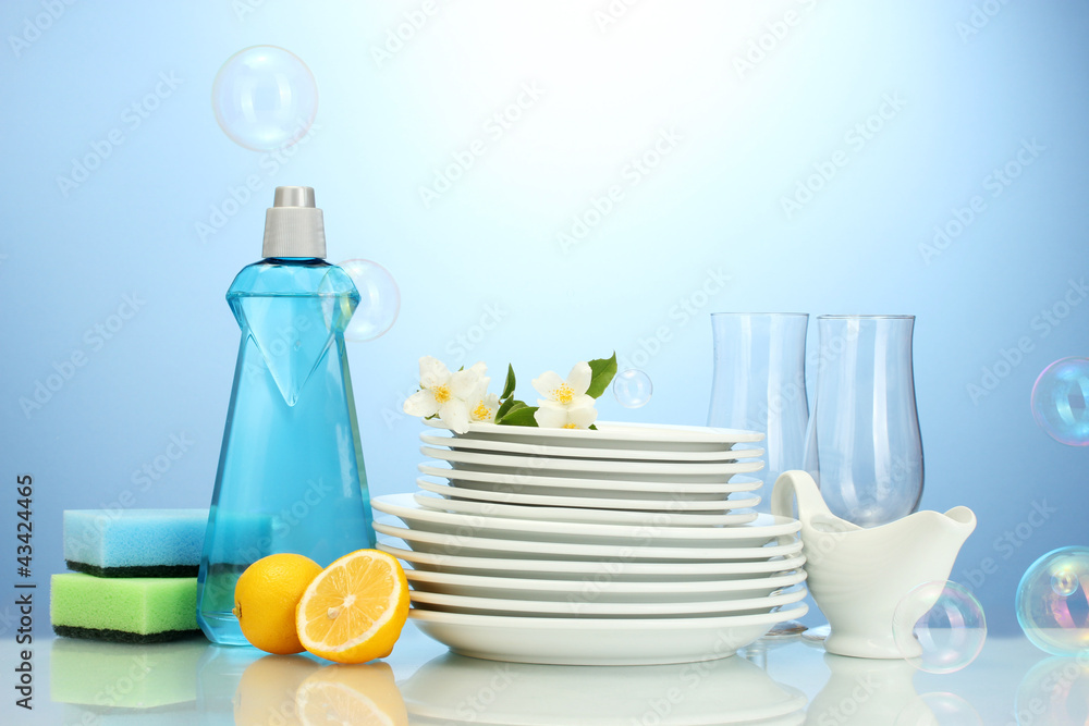 empty clean plates and glasses with dishwashing liquid, sponges