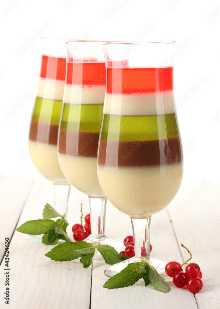 fruit jelly in glasses, redcurrants and mint on wooden table
