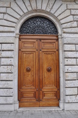 Wall Mural - Wooden door and a stone wall, buildings Tuscany