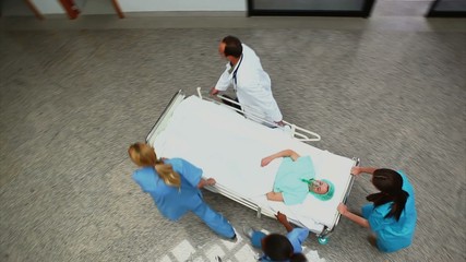 Sticker - High angle view of a medical team pushing a patient on a bed