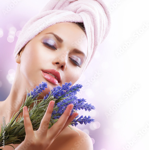 Fototapeta na wymiar Spa Girl with Lavender Flowers. Beautiful Young Woman After Bath