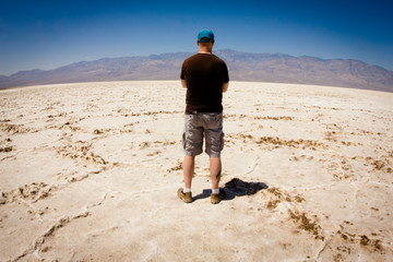 Canvas Print - Man looking out over vast salt flat in Death Valley  California