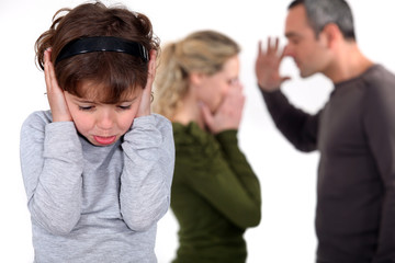 Young girl trying to block out the sound of her parents arguing