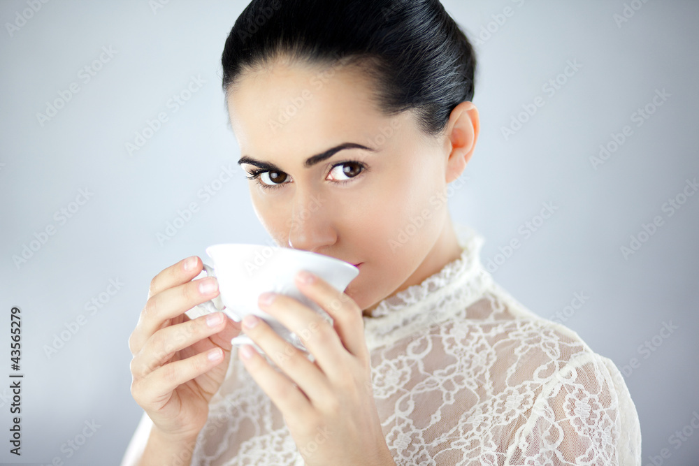 Pewna siebie kobieta pijąca aromatyczną herbatę z cukrem - obrazy, fototapety, plakaty 