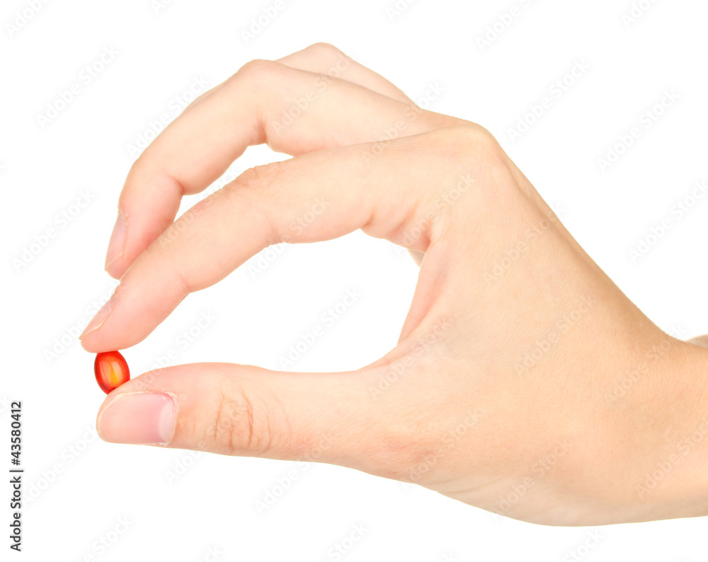 Woman's hand holding a red pill on white background close-up