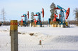 © kos1976 - Столб с надписью 'Газ' на фоне нефтяных качалок