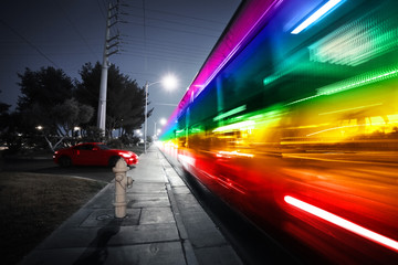 Rainbow spectrum blurred motion city bus at night