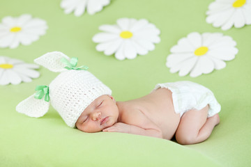 Fototapete - newborn baby girl sleeping on green meadow among daisy