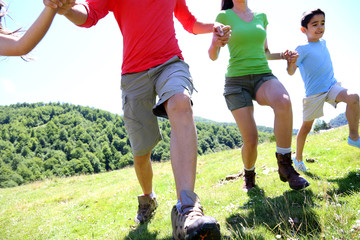 Wall Mural - Happy family enjoying and running together in the mountains