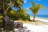 Fototapeta  - Wooden bench and footrest at a white sands beach, Seychelles