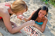© M-Production - Two girls playing chess on the beach