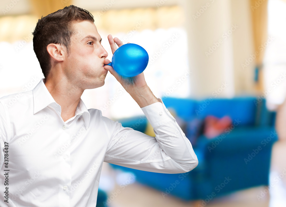 Portrait Of Young Man Blowing Balloon
