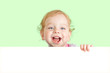 © Andrey Kuzmin - Happy child face behind blank advertising banner. Banner and gre