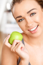 Pretty Healthy Young Woman Smiling Holding A Green Apple