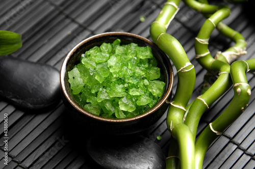 Fototapeta na wymiar bowl of Green bath salt with zen stones and lucky bamboo on mat