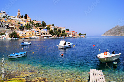 Board z aluminiowym obramowaniem Kolorowa dzielnica portowa miasta symi, grecja