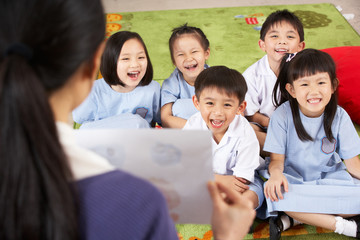 Teacher Showing Painting To Students In Chinese School Classroom