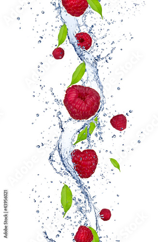 Naklejka na kafelki Fresh raspberries falling in water splash