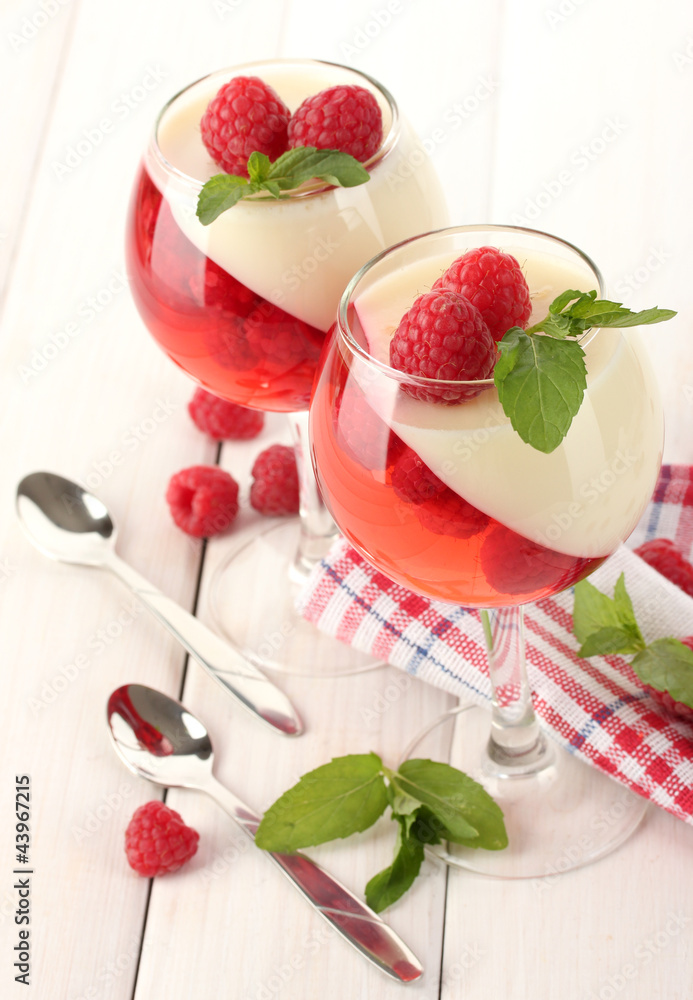 fruit jelly with raspberries in glasses on wooden table