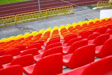 Close Up Of Rows Of Red Orange And Yellow Stadium Chairs