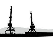 Silhouettes Of Two Port Cranes In Port