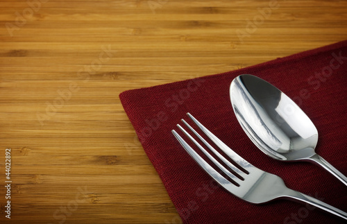 Board z aluminiowym obramowaniem Łyżka ze stali nierdzewnej i widelec na serwetce lnianej