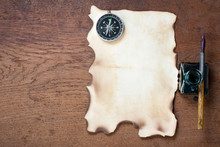 Burnt Grunge Paper, Compass, Pen And Inkwell On Wood
