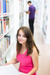 © lightpoet - Pretty young college student in a library (shallow DOF; color to