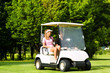 Junges sportliches Paar mit Golfcart am Golfplatz