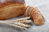 Fototapeta Kuchnia - Fresh bread with ears of wheat on the canvas.