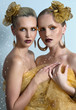 Vogue style portrait of two women with gold makeup