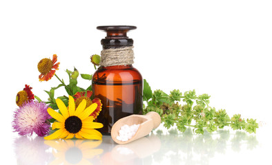 medicine bottle with tablets and flowers isolated on white