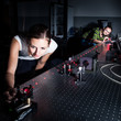 © lightpoet - Female scientist doing research in a quantum optics lab