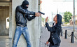 © M-Production - Bandit with a gun threatening young woman in the street