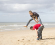 Two teenage lads playing leapfrog on the beach