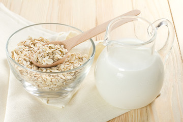 Wall Mural - Oat flaks on a glass bowl and jug of milk