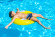 © borissos - Boy floating on an inflatable circle in the pool.