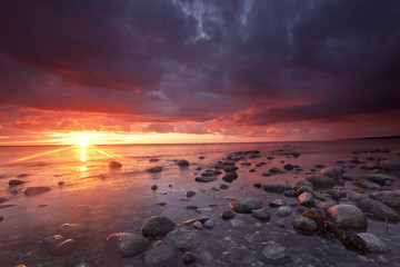 Wall Mural - Sunrise over ocean, stormclouds approaching